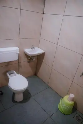 a bathroom with a toilet and a sink at ERA Heritage Inn in Kozhikode