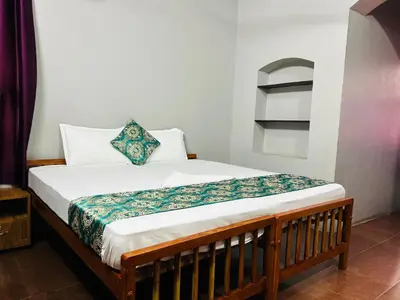 a bedroom with a bed with a wooden frame at ERA Heritage Inn in Kozhikode