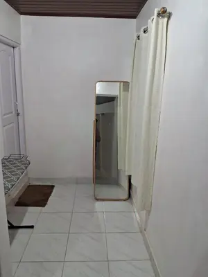 a mirror sitting on a wall in a room at Fireflies R in Madikeri