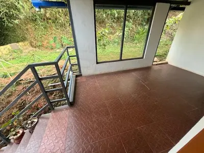 a room with a staircase and windows in a house at Fireflies R in Madikeri