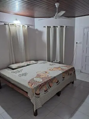 a bed in a room with curtains and a bed sidx sidx sidx at Fireflies R in Madikeri