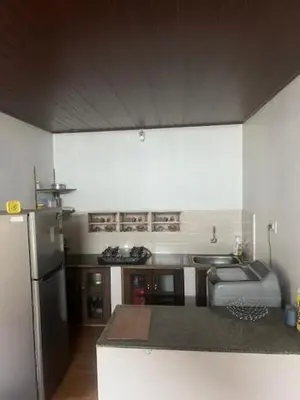 a kitchen with a refrigerator and a counter top at Fireflies R in Madikeri