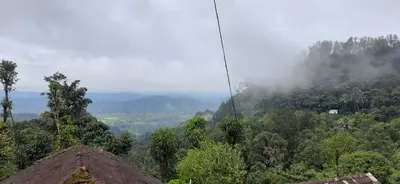 a view of a mountain with clouds in the sky at Spinson Home Stay in Madikeri