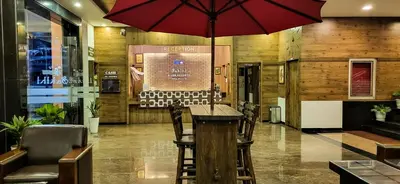 a restaurant with a table with a red umbrella at Sakthi River Resort in Pollāchi