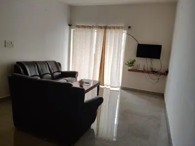 a living room with a couch and a television at Temple Bells in Mysore