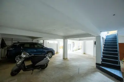 a scooter parked in a garage with a car at Cute Corner Homestay,Ooty in Ooty