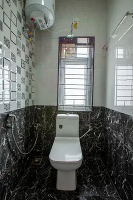 a bathroom with a white toilet and a window at Cute Corner Homestay,Ooty in Ooty