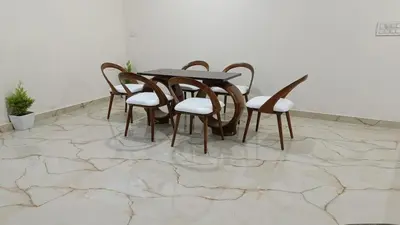 a table and chairs on a marble floor at Eve Service apartment in Mysore