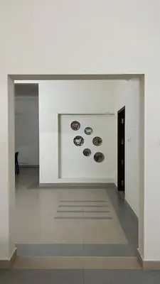 a white room with paintings on a wall at Aura Villa in Kozhikode