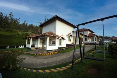 a house with a swing in front of it at Green Leaves The Countryside Inn in Ooty