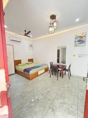 a bedroom with a bed and a table at GRAYSTONE HOMESTAY, Omassery in Tāzhekkod