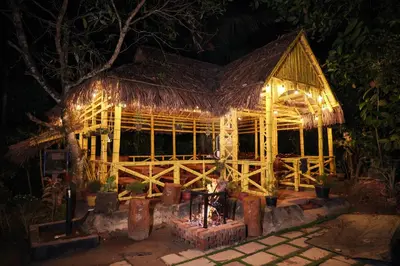 a wooden building with lights on it at night at Wayanad Vista Palm View Homes in Padinjarathara