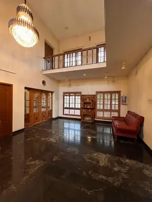 a large living room with a couch and a chandelier at Vasantham Home Stay in Satyamangalam
