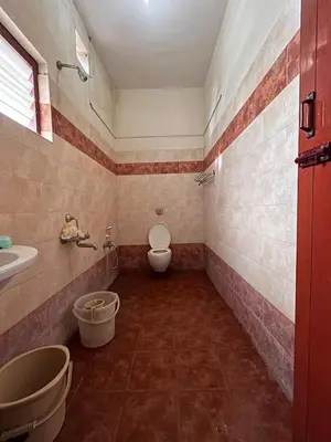 a bathroom with a toilet and a sink at Vasantham Home Stay in Satyamangalam