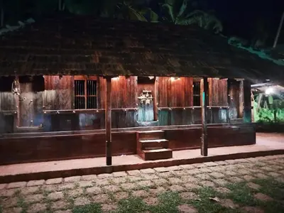 a wooden building with stairs in front of it at night at whispering waters in Kozhikode
