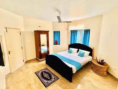 a bedroom with a bed with blue pillows and a mirror at BR Villa in Kodaikānāl
