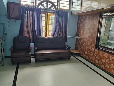 a living room with two chairs and a window at Wild mist in Padinjarathara