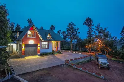a house with a car parked in front of it at Valley View by Xploreindo in Pandalūr