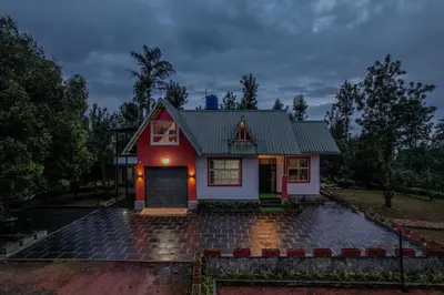 a red and white house with a driveway at Valley View by Xploreindo in Pandalūr