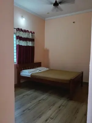 a bedroom with a bed in a room with a window at MM comforts in Mysore