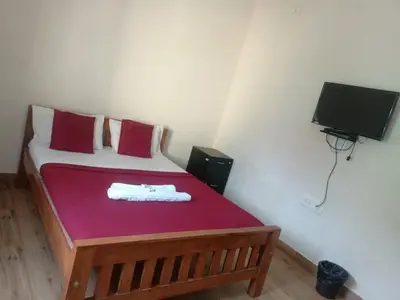 a small bedroom with a bed with a red blanket at MM comforts in Mysore