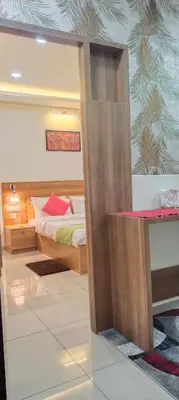 a bedroom with a bed and a desk with a mirror at Sree Nandhanam Apartment's in Guruvāyūr