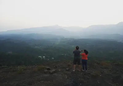 a man and woman standing on top of a mountain at Dhanagiri Homestay Wayanad in Vythiri