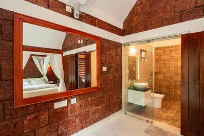 a bathroom with a brick wall and a mirror at Misty Forest Resort Wayanad in Wayanad