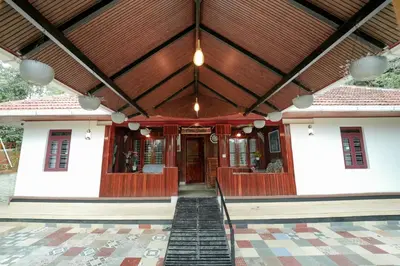 a building with a wooden ceiling and a porch at Wayanad Vista Family Bungalow in Padinjarathara