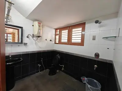 a bathroom with a sink and a toilet and a window at 6bhk Luxury Villa in Mysore