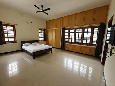 a bedroom with a bed and a ceiling fan at 6bhk Luxury Villa in Mysore