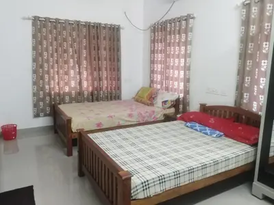 two beds in a room with curtains at 2BHK Flat At Chalakudy Town Konuparamban Residence A1 in Kizhake Chālakudi