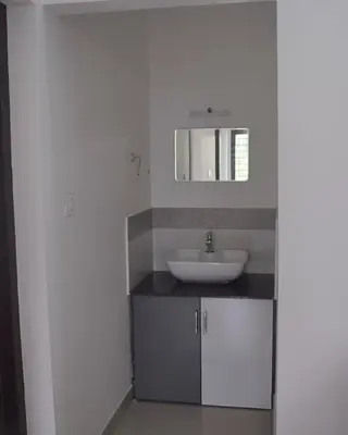 a bathroom with a sink and a mirror at 2BHK Flat At Chalakudy Town Konuparamban Residence A1 in Kizhake Chālakudi