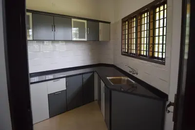 a kitchen with a sink and a counter top at 2BHK Flat At Chalakudy Town Konuparamban Residence A1 in Kizhake Chālakudi