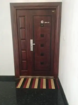 a wooden door with a rug in front of it at 2BHK Flat At Chalakudy Town Konuparamban Residence A1 in Kizhake Chālakudi