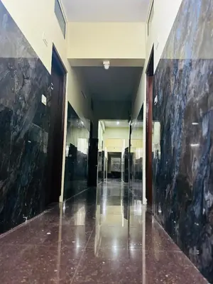 a hallway of a building with black marble walls at Avini Stay in Mysore