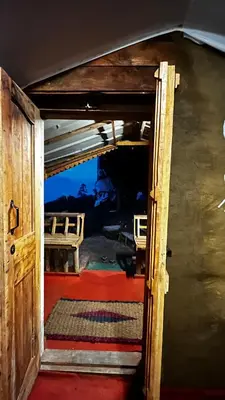 an open door into a room with a red carpet at Alpine Mud house Kanthalloor in Kanthalloor
