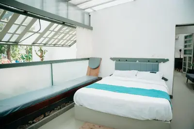 a bedroom with a large bed and a bench at Malhar - Your Home Beneath The Clouds in Sultan Bathery