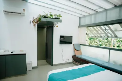 a bedroom with a bed and a sink and a window at Malhar - Your Home Beneath The Clouds in Sultan Bathery