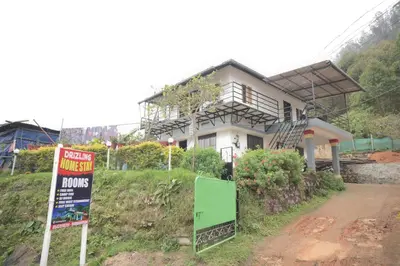 a house on a hill with signs in front of it at Drizzling Home Stay in Vattavada