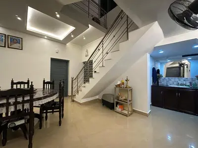 a dining room with a table and a staircase at The Chill Spot in Karuvapadna