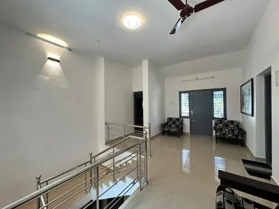 a living room with a staircase and a ceiling at The Chill Spot in Karuvapadna