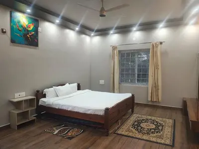 a bedroom with a large bed and a window at Coorg Ashiyana in Kushālnagar