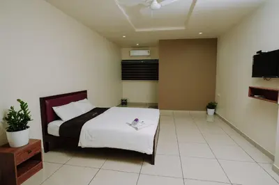 a bedroom with a bed and a flat screen tv at Atland Residency in Calicut