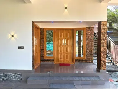 a room with a wooden door in a house at Chakkantharas Premium Villa in Athirappilly