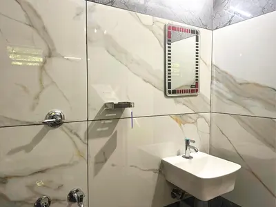 a bathroom with a sink and a shower with a mirror at Chakkantharas Premium Villa in Athirappilly