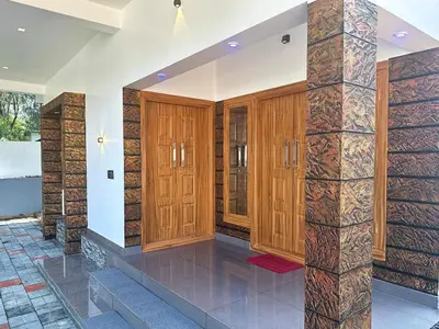 a room with wooden doors and a stone pillar at Chakkantharas Premium Villa in Athirappilly