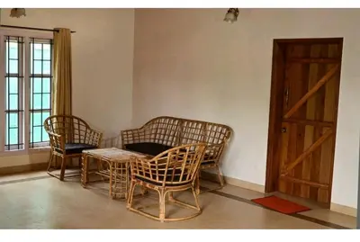 a room with three chairs and a table and a door at Deep view luxury villa Coffee Cottage Coorg in Madikeri