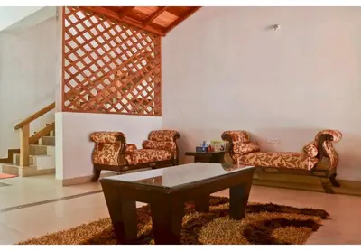 a living room with two couches and a coffee table at Deep view luxury villa Coffee Cottage Coorg in Madikeri