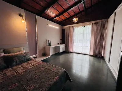 a bedroom with a bed and a large window at RiverMist Resort in Nilambūr